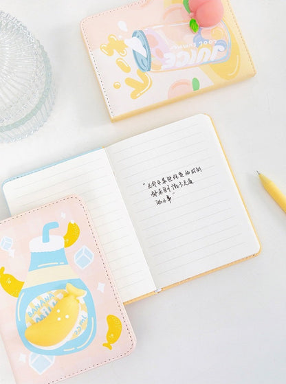 Banana Soft Leather Journal with cute banana milk design, open to lined pages showing neat handwriting, surrounded by kawaii stationery items on a white surface. Ideal for DIY planning.