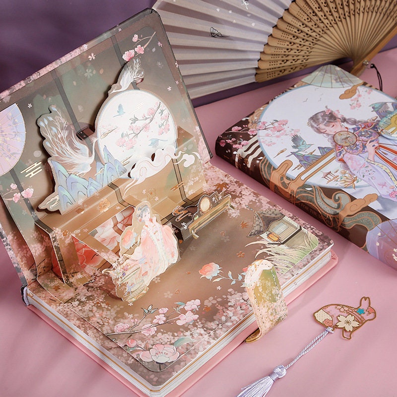 Pink Ancient Asian Beauty Planner with Metal Bookmark featuring intricate Asian-inspired art, delicate cherry blossom patterns, and elegant cultural illustrations, displayed open with a detailed pop-up scene.