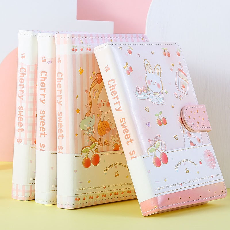 Pink Cherry Sauce A6 Journal with Magnetic Buckle featuring cute bunny and cherry illustrations, pastel colors, and "Cherry sweet sauce" text on the spine.