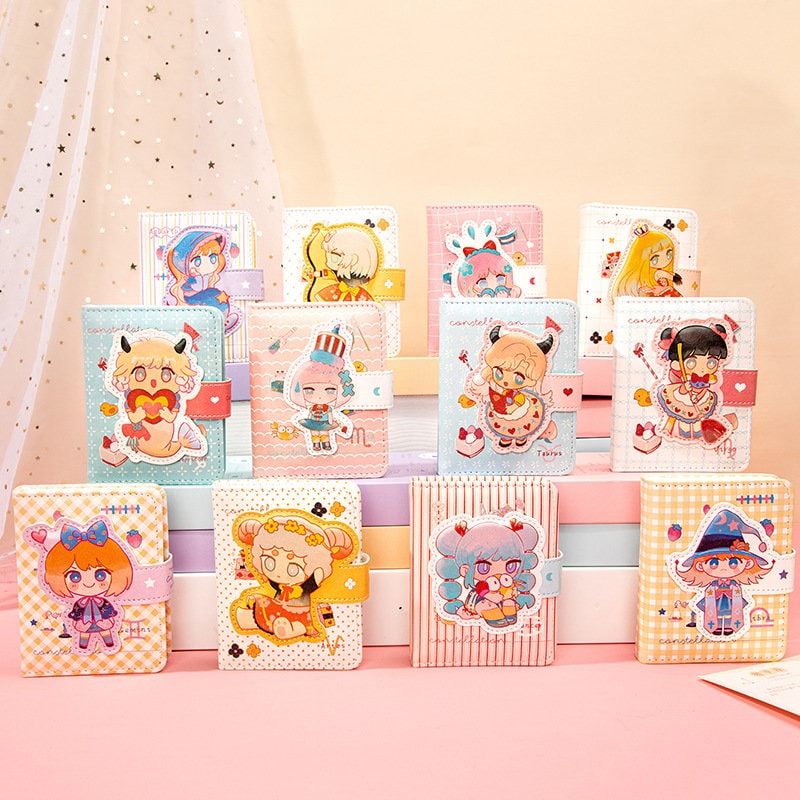 Zodiac Leather Journal - Magnetic Buckle Design featuring cute and colorful illustrations of zodiac characters in kawaii style, arranged in a neat display. Each journal has a pastel-colored cover with a magnetic buckle and charming zodiac-themed artwork. Perfect for note-taking, sketching, or as a decorative diary.