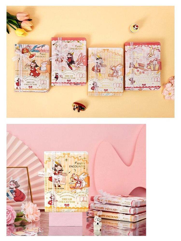 Dream Collector Magnetic Leather Notebook with Bookmark in Kawaii Style featuring cute illustrations and Happy Encounter theme, surrounded by flowers and cute figurines, perfect for journaling and note-taking.