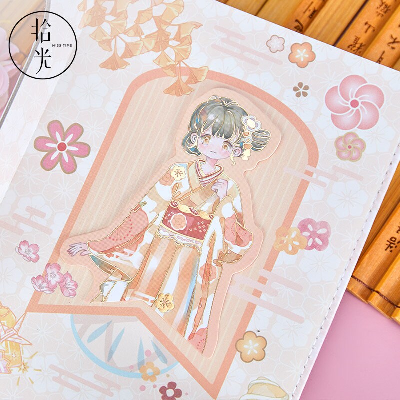 Cherry Blossom Girl Magnetic Buckle Hardcover Notebook featuring a kawaii-style illustration of a girl in traditional attire, surrounded by pastel floral motifs on a pink background.