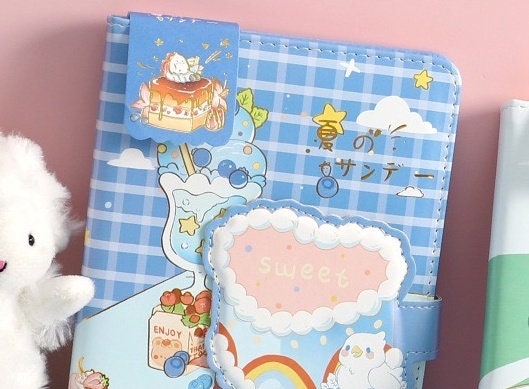 Summer Sundae Leather Journal with Magnetic Buckle featuring kawaii style, blue checkered pattern, colorful dessert illustrations, and "sweet" text.