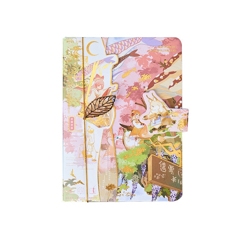 Anime hard cover journal with a whimsical, colorful illustration featuring a forest scene and characters, gold elastic band, and metal leaf bookmark. Kawaii stationery.