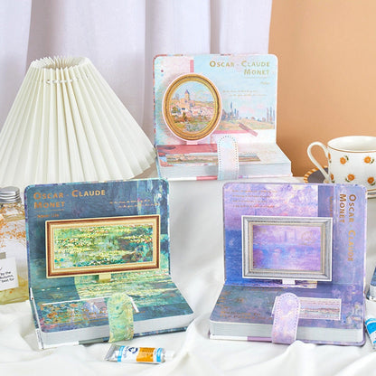 A5 Fairy Leather Journal with Bookmark and 3D Pages featuring Claude Monet art, displayed in pastel colors with intricate 3D page designs, standing on a table with a lamp and floral teacup in the background.