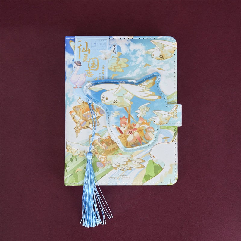 Magic World Leather Journal with colorful pages and a magnetic buckle, featuring a whimsical design of flying creatures and a blue tassel bookmark.