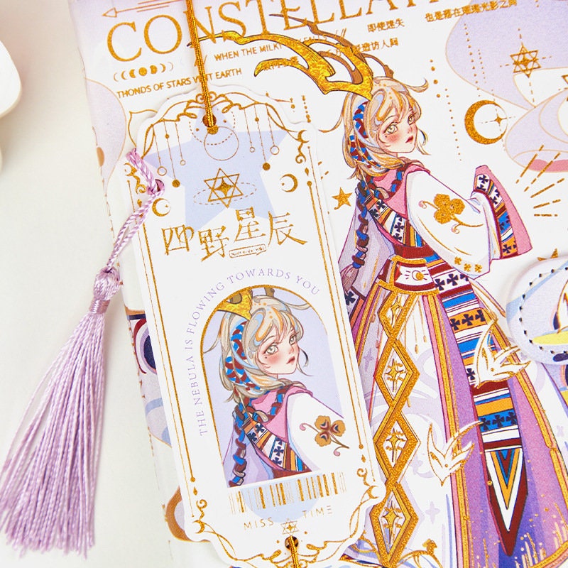 Star Beauty Leather Journal with Bookmark featuring a whimsical, celestial-themed illustration, gold accents, and a detachable lilac tassel bookmark.