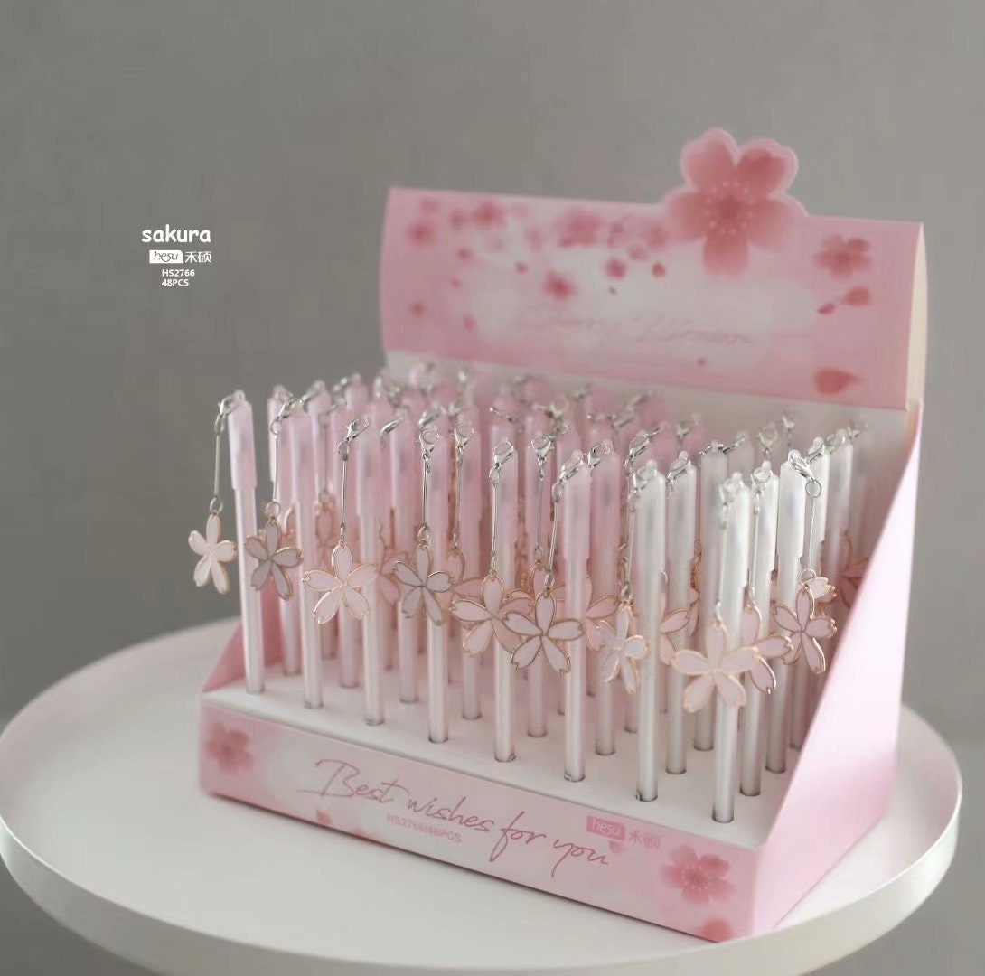 Sakura Kawaii Quick-Dry Black Gel Pen 0.5mm displayed in pink and white packaging, adorned with sakura flower charms, ideal for cute stationery collections.