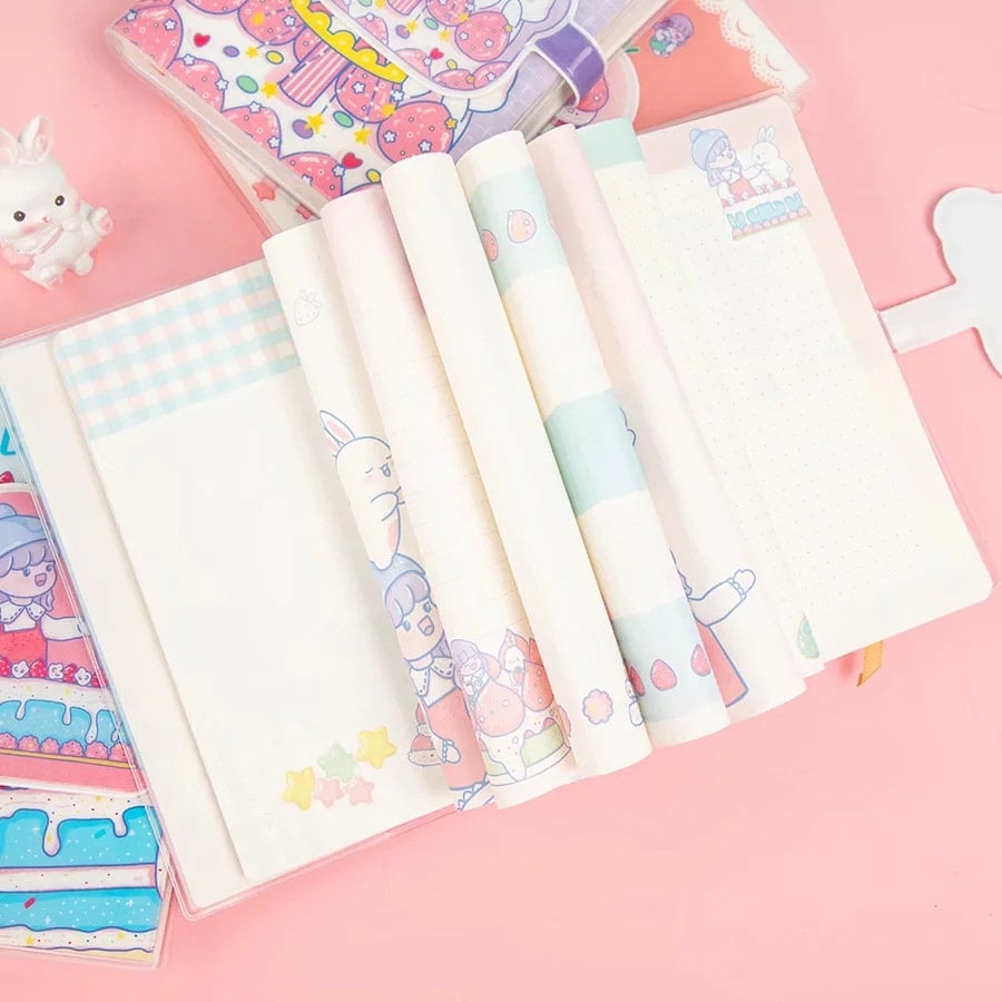 Pink magnetic buckle kawaii journal with cute illustrations and pastel colors, open pages with adorable designs and grid lines, perfect for note-taking and journaling.