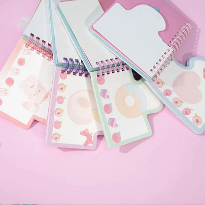 Kawaii Peach Girl Winding Journal with 180 colorful pages, featuring adorable illustrations of peaches, bunnies, donuts, and bows, spiral-bound in pastel covers on a pink background.