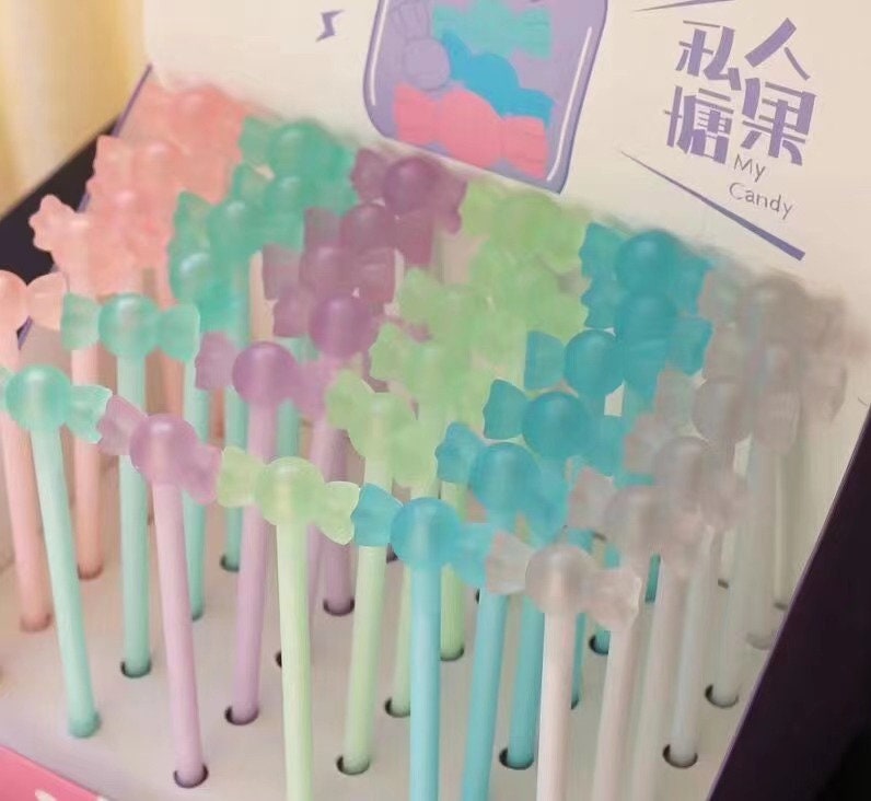 Kawaii black gel pen with 0.5mm micro point in pastel colors, featuring cute candy-shaped tops, displayed in packaging.