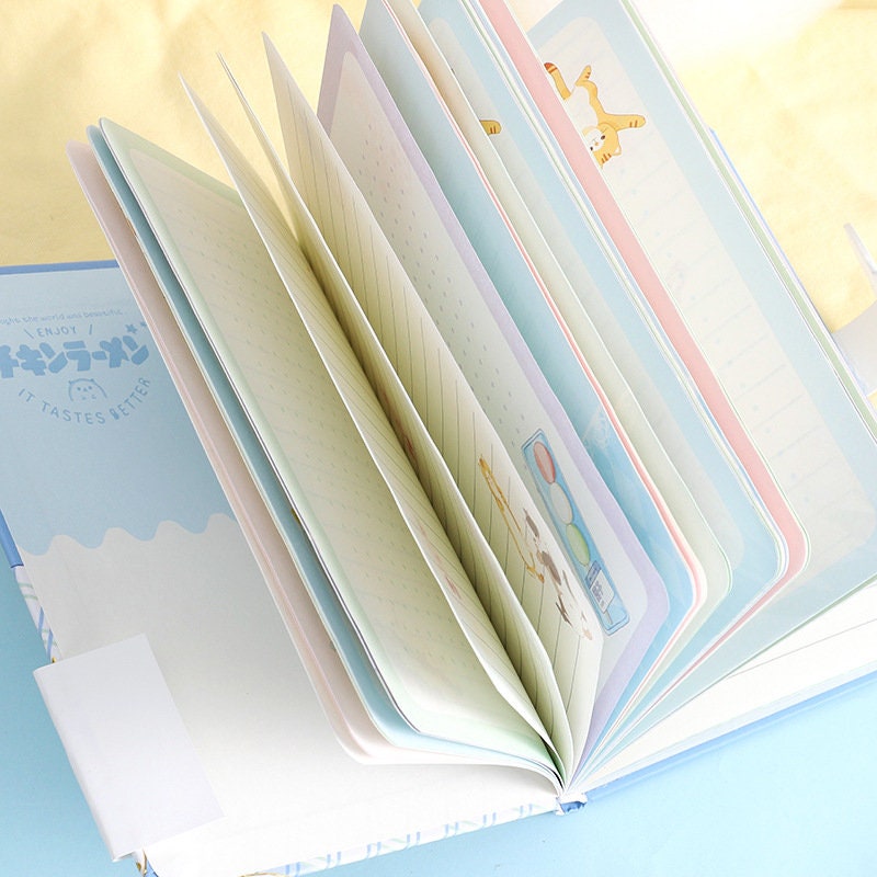 Magnetic Buckle Leather Journal with illustrated pages and "It Tastes Better" text on cover, kawaii stationery.