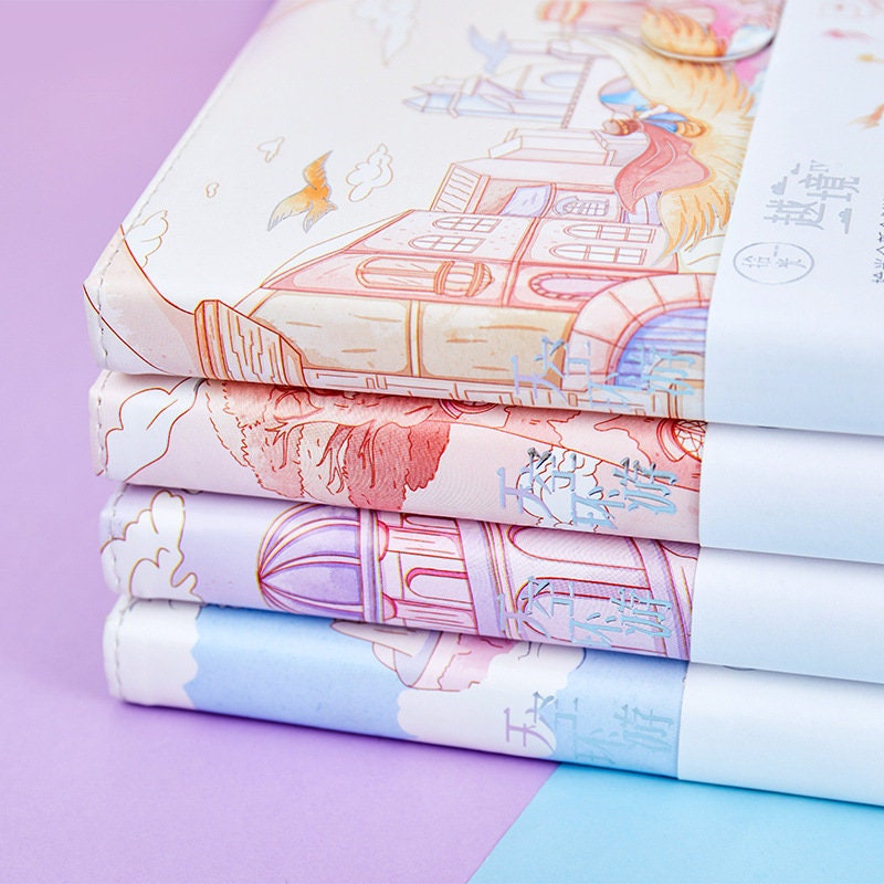 Magnetic Buckle Leather Journal - Around the Sky Design, featuring whimsical sky-themed cover illustrations stacked together, kawaii stationery.