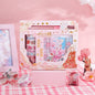 Fairyland Washi Tape Set - Craft and DIY Gift featuring various floral and pastel designs in a decorative box background; kawaii-style components including washi tape rolls, pen, and a miniature figure on a pink checkered tablecloth.