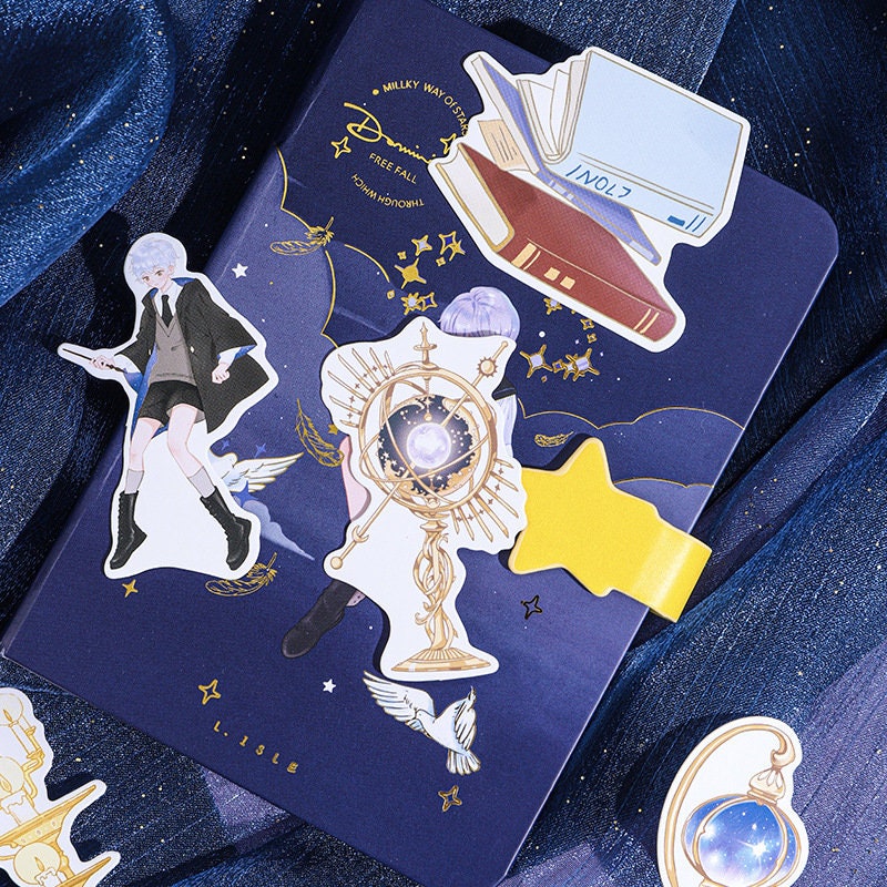 Falling Stars Decorative Sticky Notepad Set featuring celestial-themed designs with characters, books, and astrological symbols in a cute, kawaii style on a dark blue background.