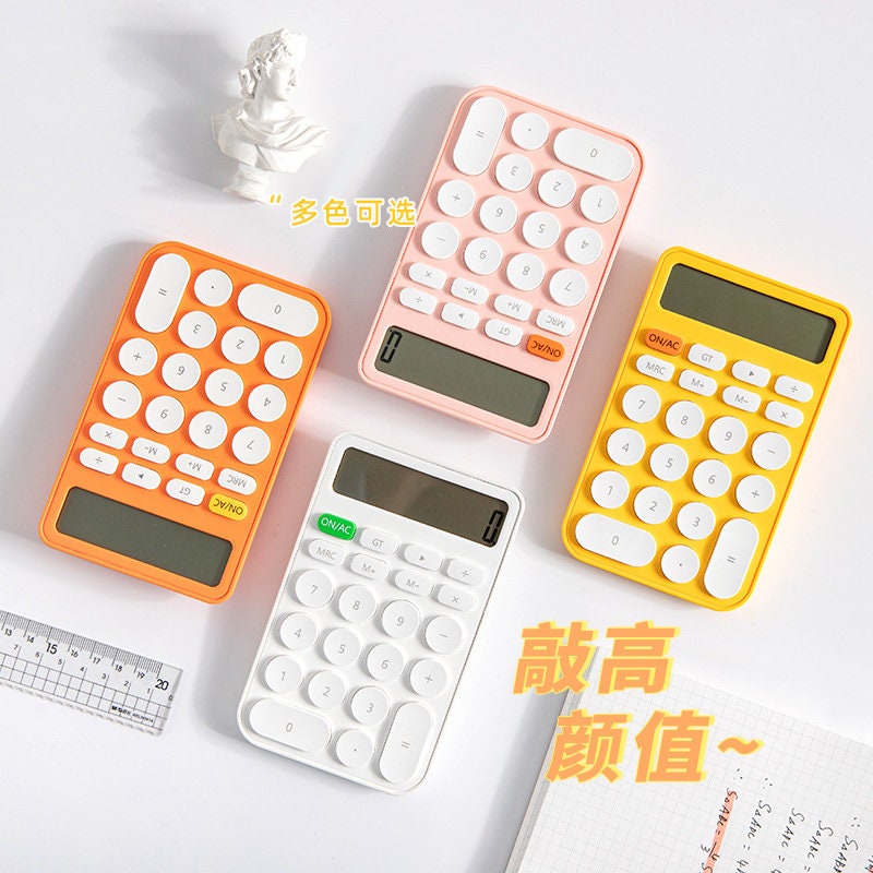 Big Button Cute Electronic Calculator in orange, pink, yellow, and white, with a kawaii design, displayed on a white background with a small statue and a ruler nearby.