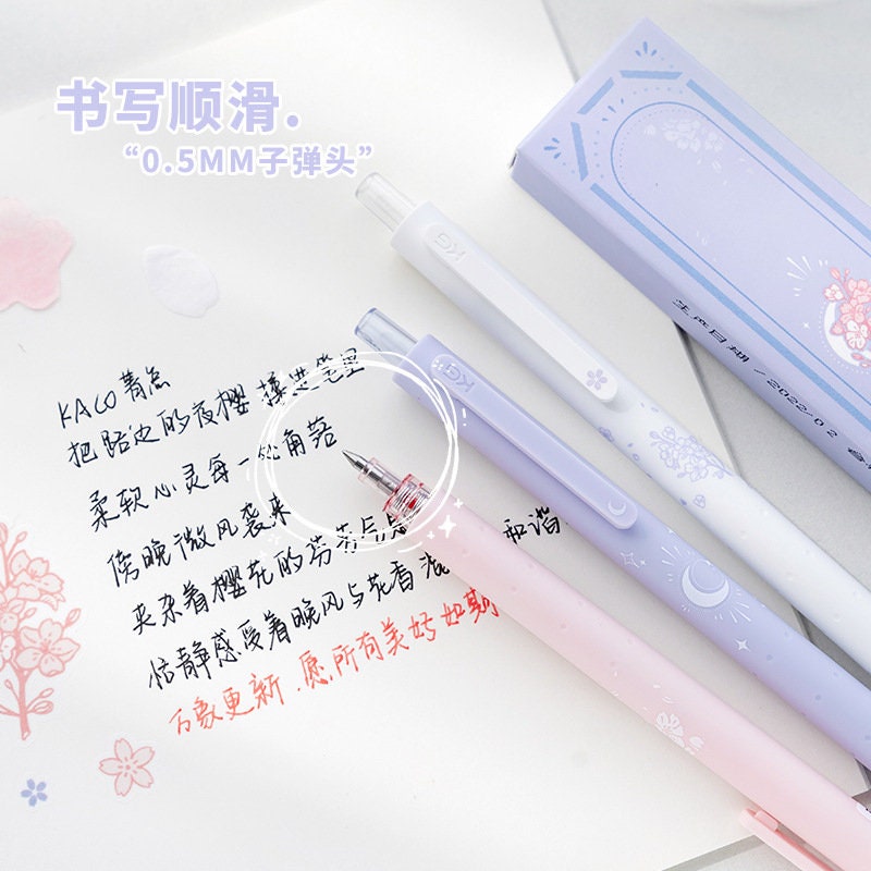 Kawaii Quick-Dry Dual Color Micro Pen with 0.5mm tip in pastel pink and purple, featuring cute designs and a sample of smooth writing on paper.