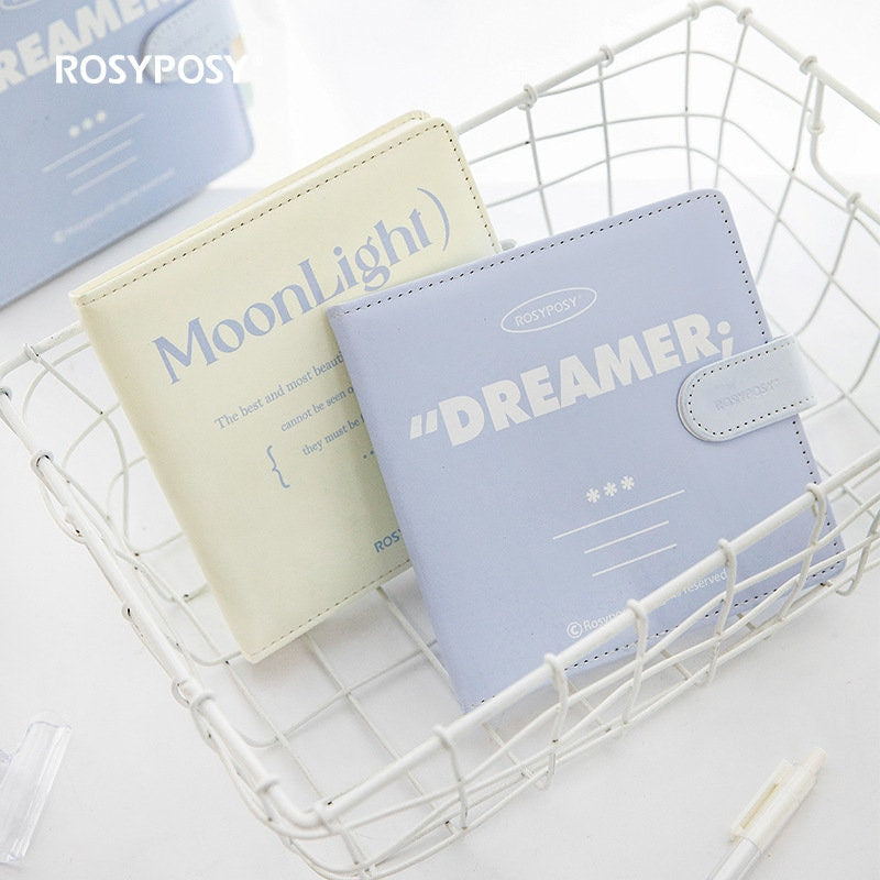 Moonlight Dreamer Colorful Journal - 84 Pages in blue and cream colors, displayed in a white wire basket, with elegant and minimalist design, perfect for creative writing and note-taking.