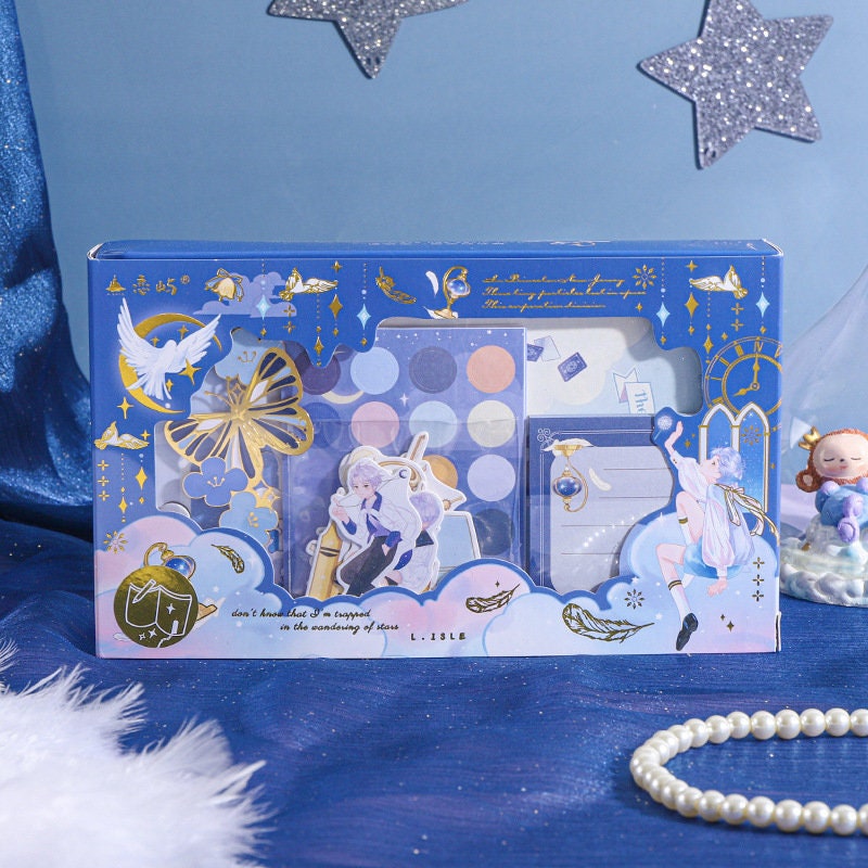 Falling Stars Decorative Sticky Notepad Set in celestial-themed packaging with dreamy blue and gold accents, featuring various sticky notes and a notepad with star and moon designs.