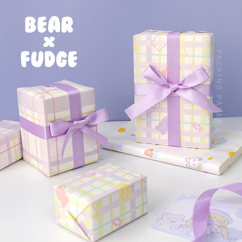 Kawaii pastel gift wrapping paper featuring a plaid pattern with cute bear and fudge designs, presented in six sheets with lavender ribbons, perfect for adorably packaged presents.