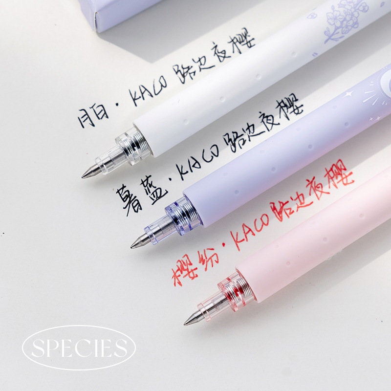 Kawaii quick-dry dual color micro pen set showing white, light purple, and pink pens with fine tips writing on white paper